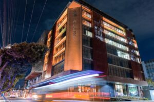 Fachada da Alese iluminada na cor laranja.